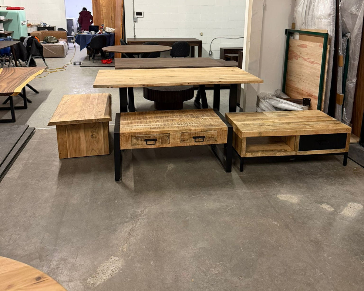 Wooden furniture set including tables and benches in a warehouse setting.