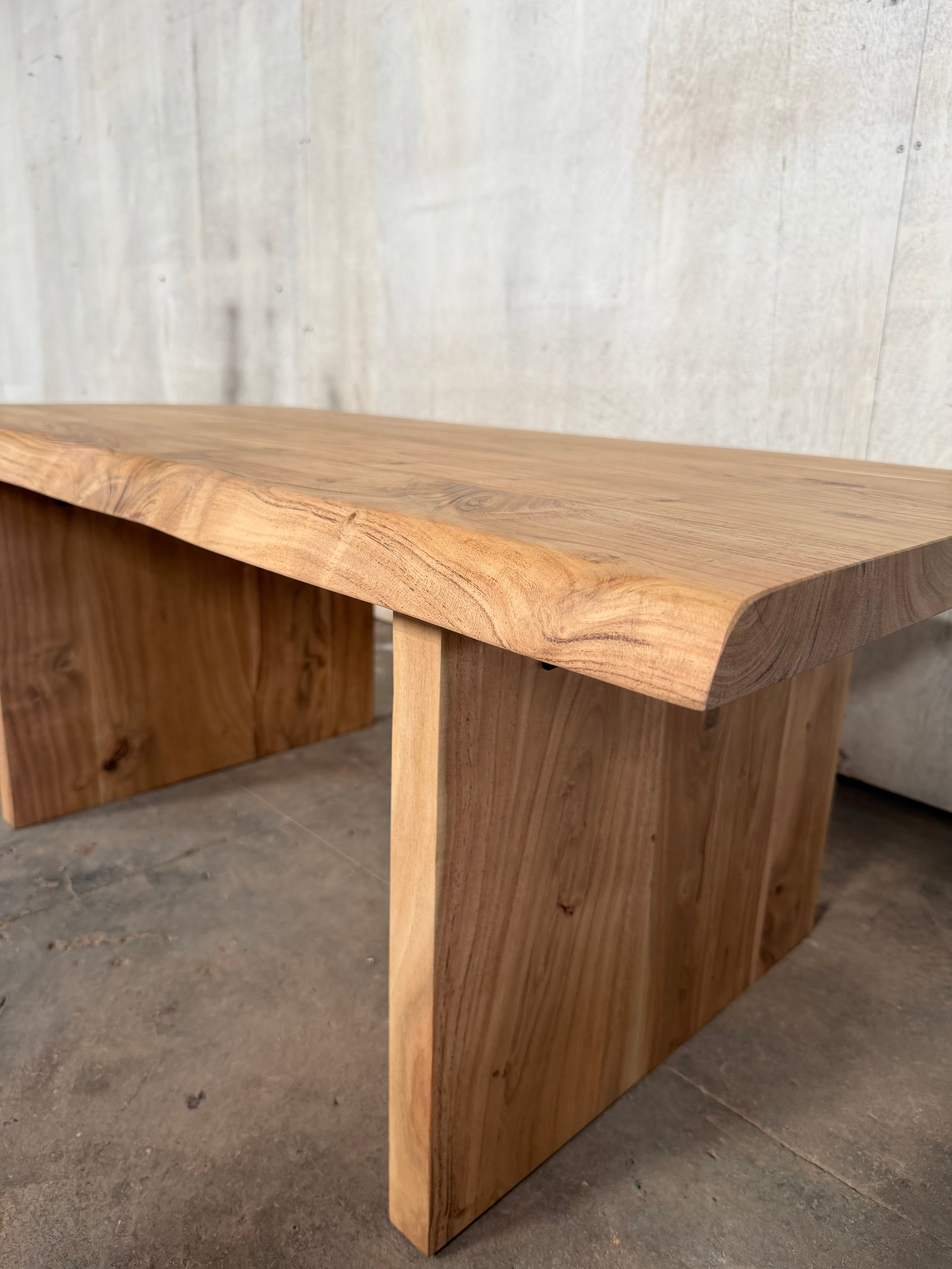Close up of acacia wood grain in dune finish against concrete wall