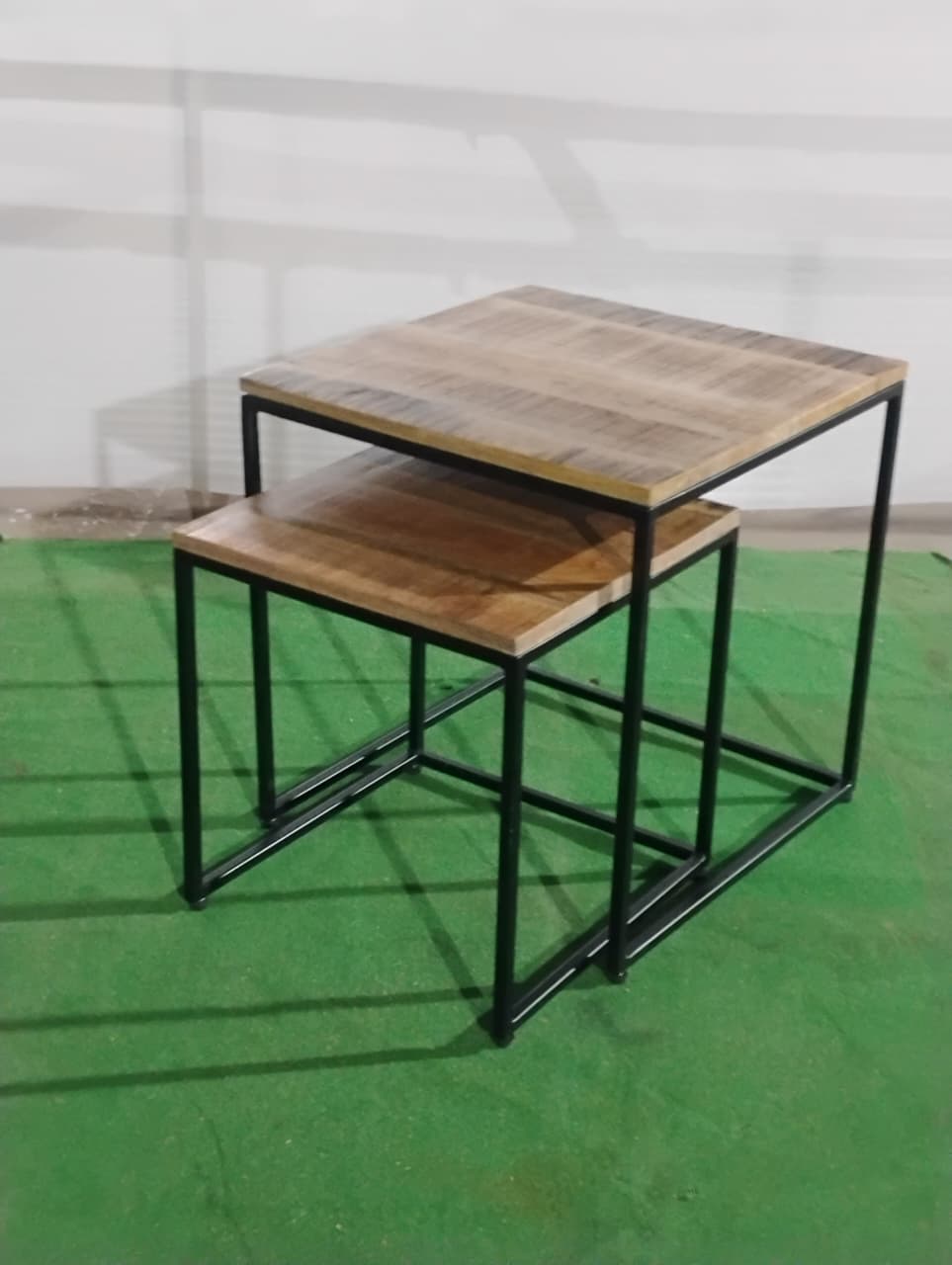 45 Angled view of Acacia Studio nesting tables with black metal frame